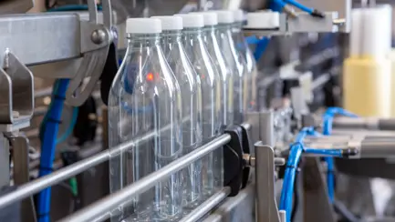 Lely Orbiter'da bir üretim hattı boyunca ilerleyen boş plastik süt şişeleri.